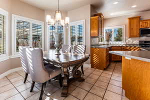 Tiled dining space with an inviting chandelier and a wealth of natural light