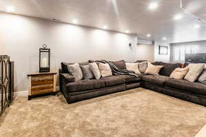 Living room with light colored carpet and a textured ceiling