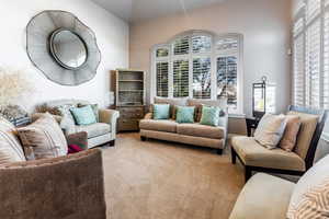 Carpeted living room with lofted ceiling