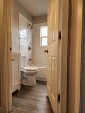 Bathroom featuring hardwood / wood-style floors, tiled shower / bath combo, a textured ceiling, and toilet