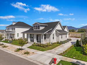 View of front of home with a mountain view, a front lawn, and covered porch