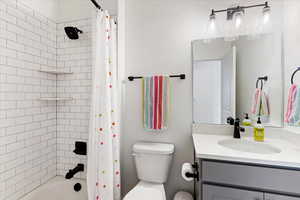 Full bathroom featuring vanity, toilet, and shower / tub combo with curtain