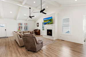 Living room featuring vaulted ceiling with beams, ceiling fan, and light hardwood / wood-style floors