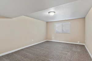 Empty room with carpet floors and a textured ceiling