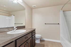 Full bathroom featuring vanity, toilet, and shower / bath combo with shower curtain