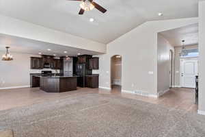 Kitchen with dark brown cabinetry, sink, black appliances, a center island, and hanging light fixtures