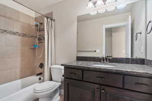 Full bathroom with vanity, hardwood / wood-style flooring, toilet, and shower / tub combo with curtain