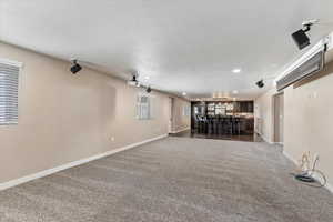 Basement with a textured ceiling and indoor bar