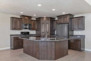 Kitchen with sink, light wood-type flooring, dark brown cabinetry, and black appliances