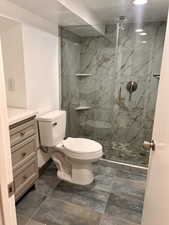 Bathroom with vanity, toilet, and a shower with door