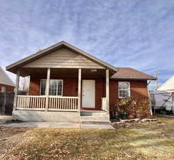 View of front of home with a porch and a front yard