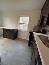 Kitchen featuring sink, dark brown cabinetry, and stainless steel appliances