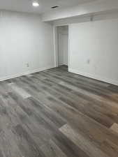 Interior space featuring baseboards, visible vents, and dark wood-style flooring