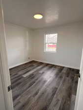 Spare room with dark hardwood / wood-style floors and ornamental molding