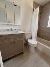 Full bathroom with vanity, shower / bath combination with curtain, and toilet