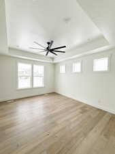 Master Bedroom with a healthy amount of sunlight, hardwood, and a tray ceiling.