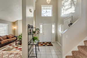 Entryway featuring a high ceiling and light tile patterned flooring