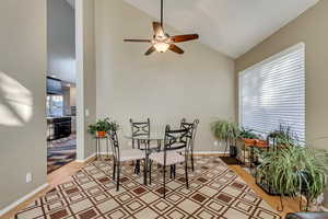 Dining area with hardwood / wood-style flooring, ceiling fan, and vaulted ceiling