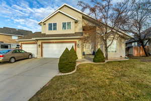 View of front of house featuring a front lawn and a garage