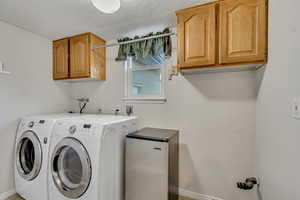 Washroom featuring cabinets and independent washer and dryer