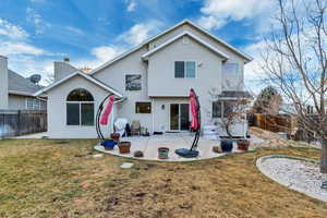 Rear view of house with a patio area and a lawn