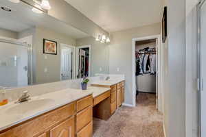 Bathroom featuring vanity and a shower with door