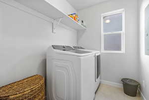 Laundry room featuring washer and clothes dryer and light tile patterned floors