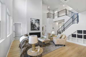 Living room with hardwood / wood-style flooring and a towering ceiling