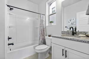 Full bathroom featuring tile patterned flooring, shower / tub combo with curtain, vanity, and toilet