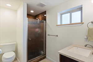 Bathroom with vanity, toilet, and walk in shower