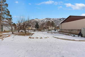 Yard covered in snow with a mountain view