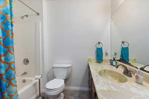 Full bathroom featuring vanity, toilet, and shower / tub combo with curtain