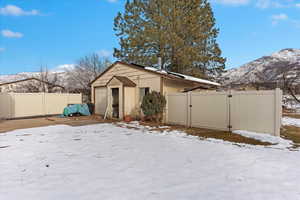 Snow covered back of property with a mountain view