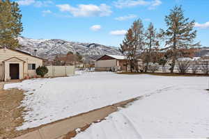 Yard layered in snow with a mountain view