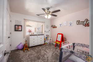 Carpeted bedroom featuring ceiling fan