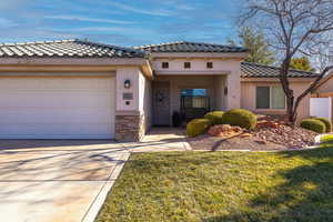 View of front facade featuring a garage and a front lawn