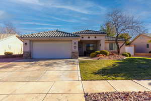 Mediterranean / spanish-style house featuring a front lawn and a garage