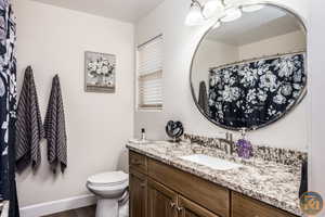 Bathroom with wood-type flooring, vanity, and toilet