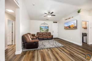 Living room featuring dark hardwood / wood-style flooring, ceiling fan, and lofted ceiling