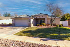 Mediterranean / spanish-style home featuring a garage and a front lawn