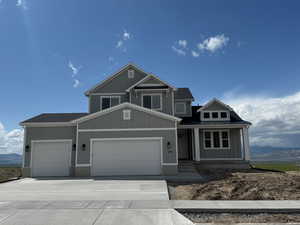 Craftsman house with covered porch, a standing seam roof, metal roof, concrete driveway, and an attached garage