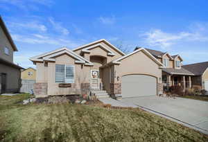 View of front of home with a garage and a front lawn