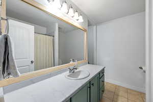 Bathroom with tile patterned floors and vanity