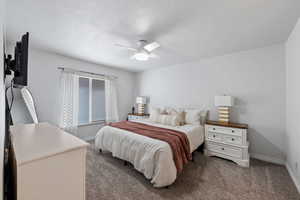 Carpeted bedroom featuring ceiling fan and a textured ceiling