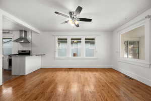 Unfurnished living room featuring light hardwood / wood-style floors, ceiling fan, and a healthy amount of sunlight