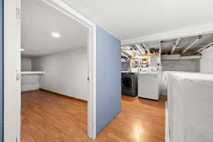 Laundry area featuring washer and clothes dryer and hardwood / wood-style flooring