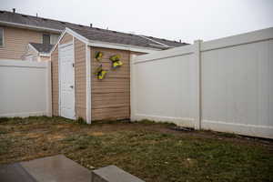 View of outdoor structure featuring a lawn