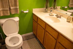 Bathroom featuring vanity, wood-type flooring, and toilet