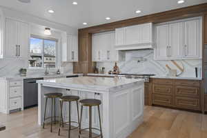 Kitchen featuring white cabinetry, a kitchen island, and stainless steel appliances