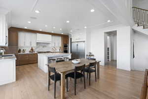 Dining room featuring crown molding, sink, and light hardwood / wood-style flooring